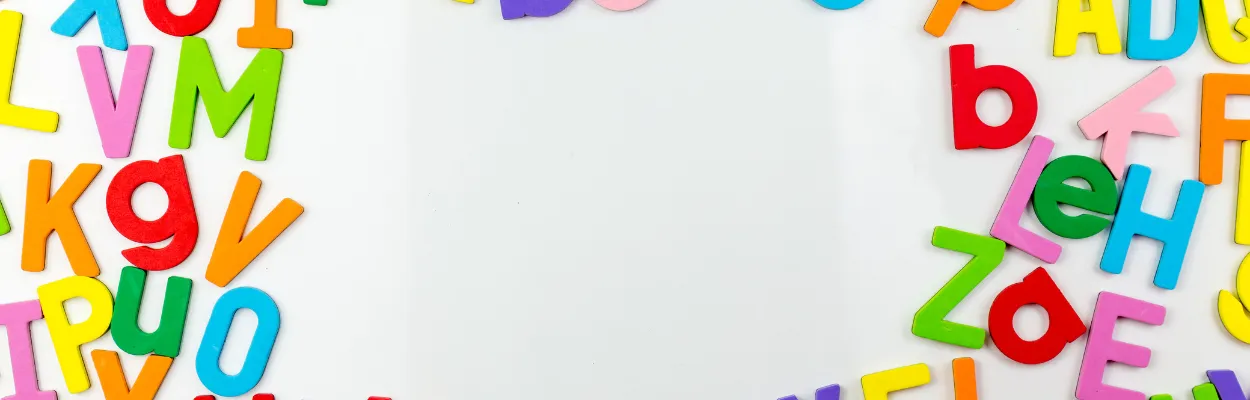 Magnesy w kształcie liter przyczepione do tablicy magnetycznej